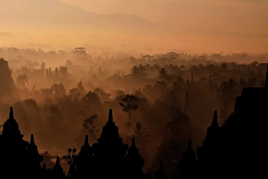 Layers of misty forest at sunrise seen from Borobudur.